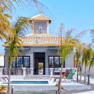 ein Haus mit einem Pool und Palmen in der Unterkunft La Casa Gris Boutique Home in Benissa