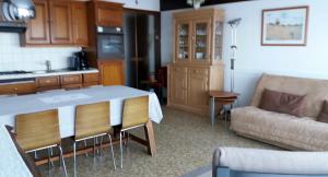 a kitchen and living room with a table and a couch at Concorde plage in Le Touquet-Paris-Plage