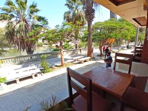 a table and benches and a river with palm trees at Hotel Sand and Lake in Ica