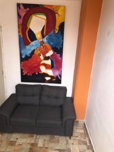 a living room with a couch and a painting on the wall at Oaxaquita la Bella in Oaxaca City