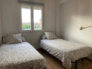 um quarto com 2 camas e uma janela em 2 baños! Piso grande 100 m2 y Garaje gratis em Madri