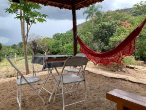 einen Tisch und Stühle unter einem Schirm in der Unterkunft Sítio Lavras do Abade in Pirenópolis