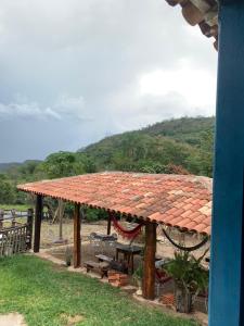 einen Pavillon mit einem Tisch, Bänken und einem Berg in der Unterkunft Sítio Lavras do Abade in Pirenópolis