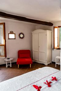 um quarto com uma cadeira vermelha e uma cama em Solemagia em Vernazza