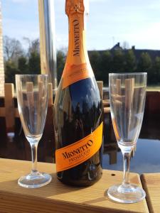 a bottle of champagne and two glasses on a table at Siedlisko Podlasie in Kuraszewo