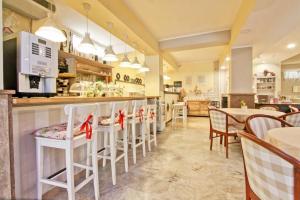 a restaurant with a bar with white stools at Hotel La Maison Delle Terme in Tivoli Terme