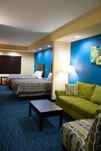 Karnes CityにあるKarnes City Lodgeのベッド2台とソファが備わるホテルルームです。