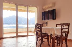 a dining room with a table and chairs and a balcony at Secret Mirage Apartment in Kotor