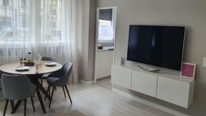 een woonkamer met een televisie en een tafel met stoelen bij Apartment im Zentrum Berlin Kudamm, City West in Berlijn