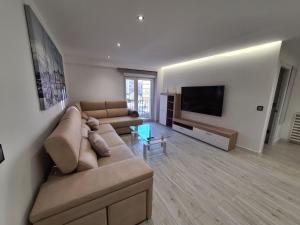 a living room with a couch and a flat screen tv at 104A Apartamento para 8 personas in Gijón