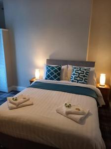 a bedroom with a large bed with towels on it at Beach Cove in Llandudno