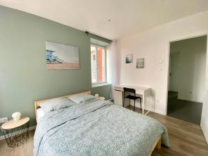 Un dormitorio con una cama y un escritorio y una ventana. en Très beau T2 42m2 lumineux, moderne et rénové avec Fibre, en Belfort