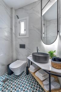 a bathroom with a sink and a toilet at Aeolia Boutique Studios in Ermoupoli