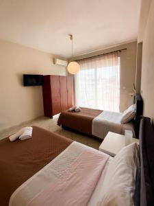 a hotel room with two beds and a window at Theros Apartment Preveza in Preveza