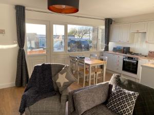 a kitchen with a couch and a table in a kitchen at Bay - Brambles Chine, Colwell Bay - 5 star WiFi - Short walk to The Hut and beach - 1 night stays available - Ferry offers in Freshwater