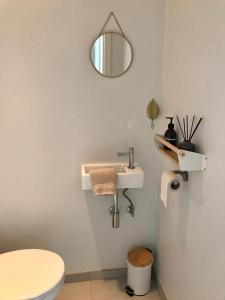 bagno con lavandino, servizi igienici e specchio di Luxury Seaview Apartment with free private garage a Ostenda