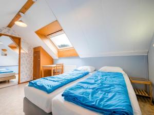 um quarto com 2 camas e lençóis azuis em Serene Holiday Home in Ulestraten near Private Forest em Ulestraten