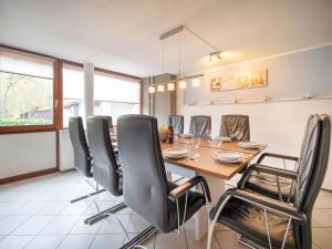 une salle à manger avec une table en bois et des chaises noires dans l'établissement Serene Holiday Home in Ulestraten near Private Forest, à Ulestraten