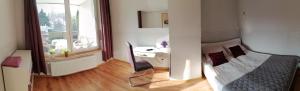 a bedroom with a bed and a desk and a window at Apartament Wiosenna in Malbork