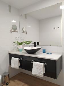 a bathroom with a sink and a large mirror at AZAHAR-Playa Home by Cadiz4Rentals in Cádiz