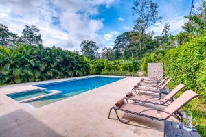 a group of chairs sitting next to a swimming pool at La Tica y La Gata in Puerto Viejo