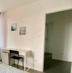 uma cadeira ao lado de uma secretária num quarto em Très beau T2 42m2 lumineux, moderne et rénové avec Fibre em Belfort