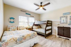 a bedroom with a bunk bed and a fan at Wineaux Chateaux in Bolivar Peninsula