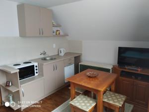 cocina pequeña con mesa pequeña y TV en Apartman Ana, en Mokra Gora