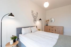 1 dormitorio con cama blanca y armario de madera en River View Apartment z prywatnym podziemnym parkingiem, en Iława