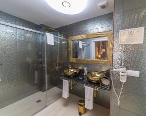 a bathroom with two sinks and a glass shower at El Rey Moro Hotel Boutique in Seville