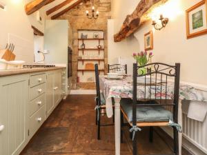 a kitchen with a table and chairs in a room at Beehive Cottage in High Bentham