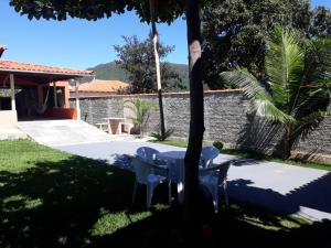 a patio with two chairs and a table in a yard at Rancho Do Claudim in Pirenópolis