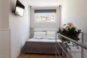 Bett in einem Zimmer mit Fenster in der Unterkunft Sicily Dreams Luxury in Agrigento