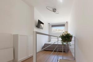 ein weißes Zimmer mit einer Treppe und einem Fenster in der Unterkunft Sicily Dreams Luxury in Agrigento