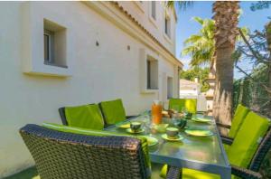 een tafel met groene stoelen en een tableasteryasteryasteryasteryasteryasteryasteryasteryasteryasteryastery bij Bahamas 1 in Son Serra de Marina