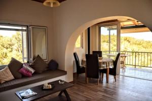 uma sala de estar com um sofá e uma mesa em Villa Sea View em Kouspádes