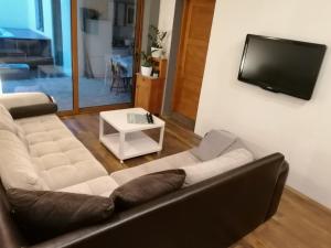 a living room with a couch and a flat screen tv at Holiday Home Kotulin in Pakoštane