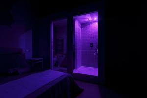 Camera scura con doccia con luci viola di Sicily Dreams Luxury a Agrigento