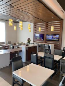 a dining room with tables and chairs and televisions at Wingate by Wyndham Murfreesboro-NEAR MTSU in Murfreesboro