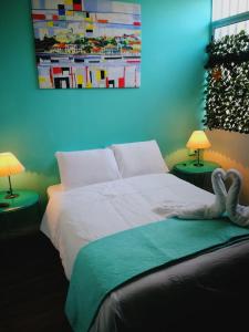 a bedroom with a bed with two lamps and a picture at NATIVUS Art-Hostel in San José