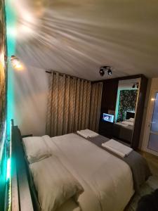 una camera da letto con un grande letto bianco e uno specchio di Apartament ultra central 2 a Hunedoara