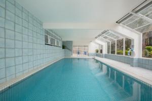 une grande piscine avec un mur carrelé bleu et une fenêtre dans l'établissement BreakFree Beachpoint, à Gold Coast