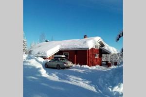 Kotila的住宿－Metsorinne 3A sarvipöllö，停在雪覆盖的房子前面的汽车