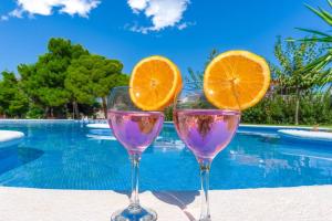 dwa kieliszki wina z plasterkami pomarańczy w nich obok basenu w obiekcie Bungalow Blue Dream 1 - Sea views, terrace and pool w mieście Gran Alacant