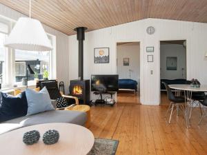 a living room with a couch and a table and a fireplace at 8 person holiday home in Ebeltoft in Ebeltoft