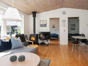エーベルトフトにある8 person holiday home in Ebeltoftのリビングルーム(ソファ、テーブル、暖炉付)