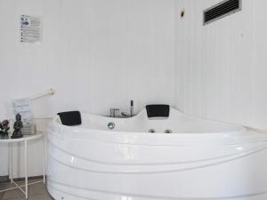 a white bath tub in a bathroom with a sink at 8 person holiday home in Ebeltoft in Ebeltoft