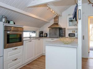 cocina con armarios blancos y fogones en 6 person holiday home in Toftlund en Vestergård
