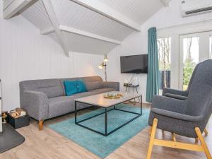 Vestergårdにある6 person holiday home in Toftlundのリビングルーム(ソファ、テーブル、椅子2脚付)
