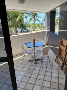 een tafel en stoelen op een balkon met uitzicht op de oceaan bij EDIFÍCIO NAUTILUS in Maceió